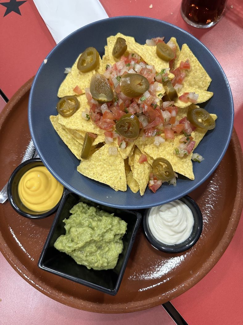 Nachos con guacamole, queso fundido y crema agria para mojar.